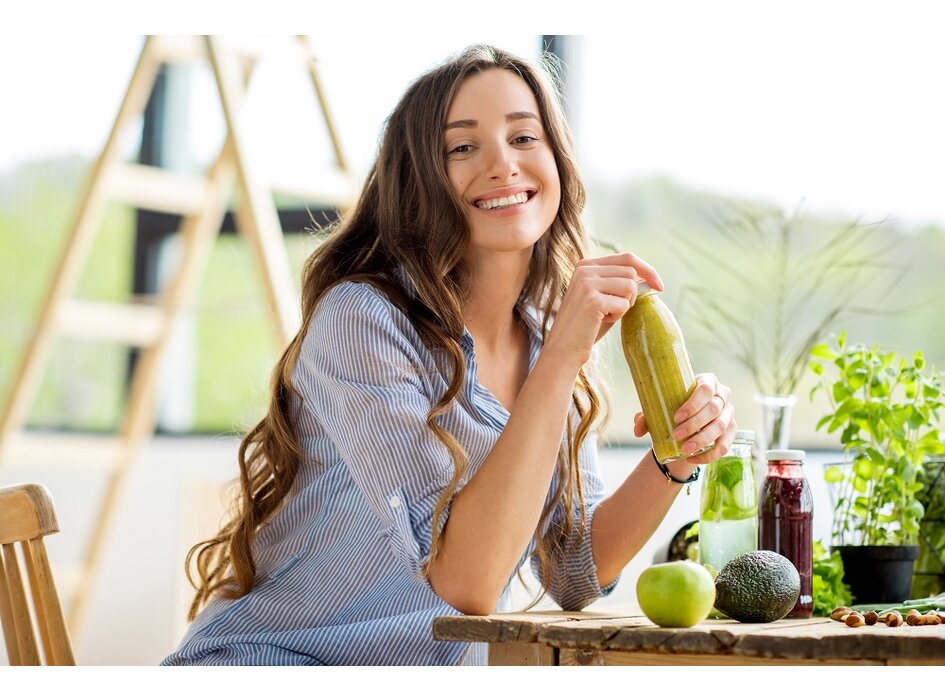 Žena, ktorý pije smoothie a usmieva sa.